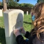 Cleaning- girl cleaning marker and headstone