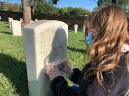 Cleaning- girl cleaning marker and headstone