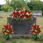 Row of flowers- red roses  at headstone markers